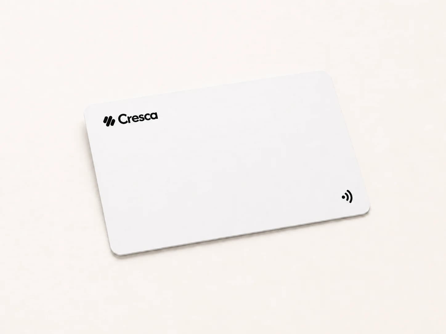 A white Cresca NFC Card on a warm stone surface